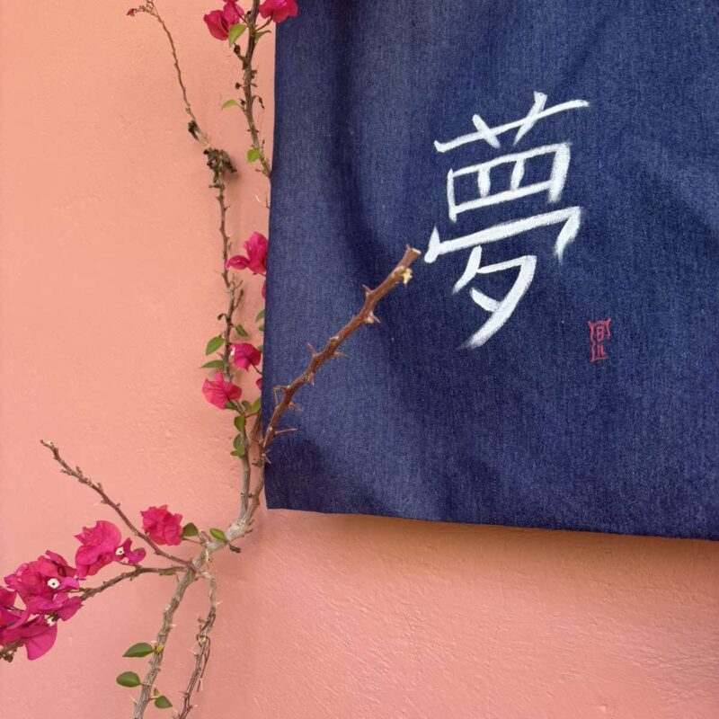 Hand-painted denim tote bag featuring the Japanese kanji 夢 (Yume), meaning "dream", in expressive white brushstrokes.